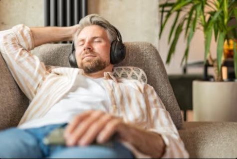 hombre escuchando audio sofa